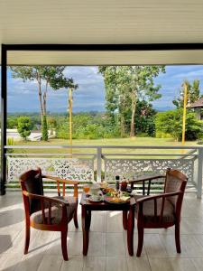 a table and chairs in a room with a large window at River valley resort แอทน่าน in Nan