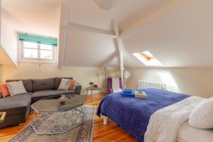 a living room with a bed and a couch at Sky Accommodations Studio in Coimbra