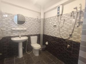 a bathroom with a shower and a toilet and a sink at Sobasee Holiday Bungalow in Kandy