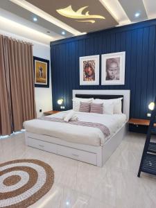 a bedroom with a large bed with blue walls at Aline Villa in Wonosobo