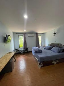 a bedroom with a bed and a desk in it at Green Garden Homestay in Ban Khlong Waet