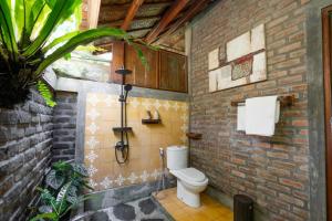a bathroom with a toilet in a brick wall at Saridevi Ecolodge in Jatiluwih +54 photos