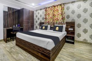 a bedroom with a large bed and a desk at Hotel Namo Again By IGI in New Delhi