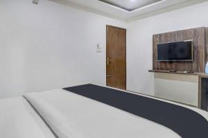 a bedroom with a bed and a flat screen tv at Hotel Namo Again By IGI in New Delhi +2 photos