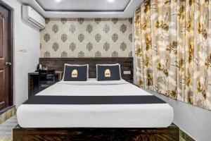a bedroom with a large white bed and curtains at Hotel Namo Again By IGI in New Delhi