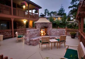 a patio with a brick fireplace with chairs and a table at Candle Light Inn in Carmel