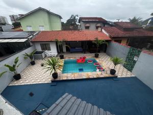 an overhead view of a swimming pool in front of a house at Casa no Condomínio CenterVille in Bertioga