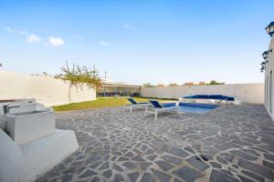 a patio with two blue chairs and a pool at Dreams Gate Villa Resthouse 4 in Umm Şalāl ‘Alī