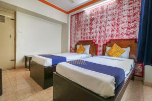 a bedroom with two beds and a red and white wall at SPOT ON Balaji Residency near Yeshwantupur Railway Station in Bengaluru