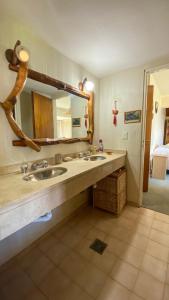 a bathroom with two sinks and a large mirror at Casa con parque y vista al lago in San Carlos de Bariloche