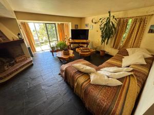 a bedroom with two beds and a living room at Casa con parque y vista al lago in San Carlos de Bariloche