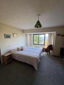 a bedroom with a large bed and a window at Casa con parque y vista al lago in San Carlos de Bariloche