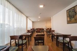 a dining room with wooden tables and chairs at Hotel Comat Deva in Deva