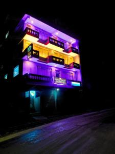 a building with purple lights on it at night at Hidden Monkey Stays Darjeeling, Batasia in Darjeeling +84 photos