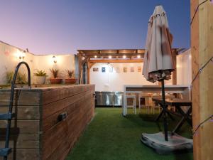 an outdoor kitchen with an umbrella and a table at צימר פלטינום - צימר עם בריכה וג'קוזי פרטיים בערד in Arad