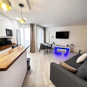 eine Küche und ein Wohnzimmer mit einer Couch und einem Tisch in der Unterkunft Babylone 2 premium in Le Pré-Saint-Gervais