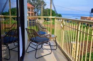 a balcony with chairs and a view of the ocean at Masese Heights in Jinja