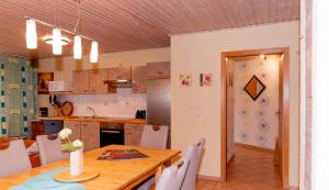 a kitchen and dining room with a wooden table at -Waldhaus-Fewo 4 in Granzow
