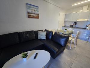 salon z czarną kanapą i stołem w obiekcie Sunny bungalow La Mata with sea views w mieście Torrevieja