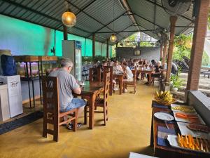 a man sitting at a table in a restaurant at Optimum Residencies in Negombo