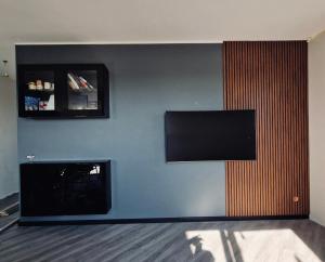 a living room with a fireplace and a flat screen tv at Penthouse in a heart of Adazi in Ādaži
