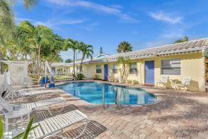 a swimming pool with lounge chairs and a house at Bahama Beach Club Pompano - Fort Lauderdale - Charming and Cozy Studios & Apartments close to Beach with Pool in Pompano Beach