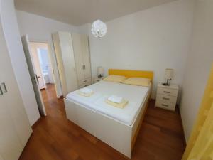 a bedroom with a white bed with two towels on it at Apartments Laus in Dubrovnik