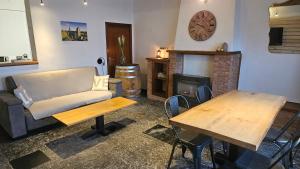a living room with a couch and a table and a fireplace at Gîte citadin de l'Entreville in Lobbes