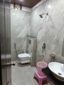 a bathroom with a white toilet and a sink at Pragya international in Varanasi