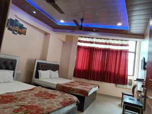 a hotel room with two beds and a window at Pragya international in Varanasi +12 photos