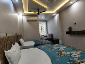 a bedroom with two beds and a ceiling fan at Pragya international in Varanasi