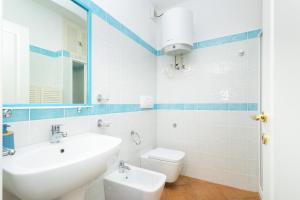 a white bathroom with a sink and a toilet at CASTELSARDO Casa Raoul Piscina e vista mare in Castelsardo +40 photos