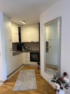 kuchnia z białymi szafkami i dużym lustrem w obiekcie Sarajevo Boulevard w Sarajewie