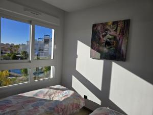 a bedroom with a bed and two windows at Bali Apartment Punta Prima in Torrevieja +17 photos