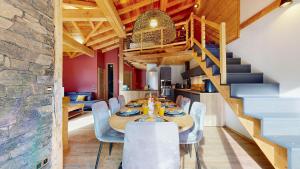 a dining room with a table and chairs and a staircase at Chalet Grand Croix - Haut Standing - 8, 10 pers in Lanslebourg-Mont-Cenis +20 photos