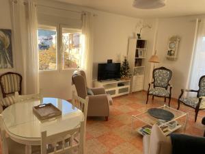 a living room with a table and chairs and a television at Apartamento El Mirador de Sierra Mágina Noalejo entre Granada y Jaén in Noalejo