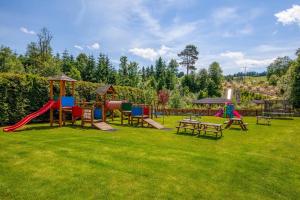 a park with a playground with tables and chairs at Villa Źródło & Spa in Krynica Zdrój