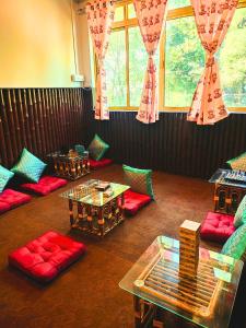 a living room with red and green couches and tables at Hidden Monkey Stays Darjeeling, Batasia in Darjeeling