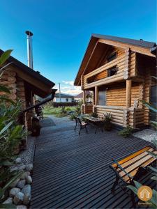 a wooden deck with benches in front of a log cabin at Dreveničkovo in Liptovský Mikuláš