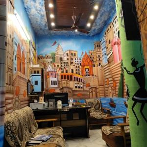 a room with a mural of a city at The Gangotri Inn in Varanasi
