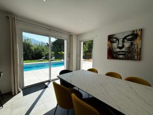 a dining room with a table and a view of a pool at Casamea - Villa Familiale, Piscine, 15 min Ajaccio in Alata +33 photos