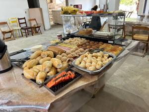 a buffet filled with different types of bread and pastries at Pousada do Cid in São Thomé das Letras