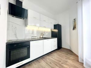 een keuken met witte kasten en zwarte apparaten bij EASY RENT- Północna Old Town View, Free Parking, 24h Check-in in Lublin