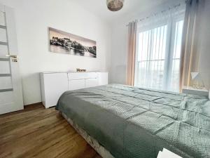 een witte slaapkamer met een bed en een raam bij EASY RENT- Północna Old Town View, Free Parking, 24h Check-in in Lublin +7 foto's