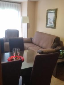 a living room with a couch and a table with wine glasses at Apartamentos Villa Sofía in San Vicente de la Barquera