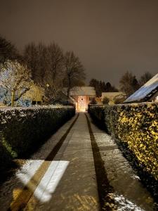 einen schneebedeckten Bürgersteig mit einem Haus im Hintergrund in der Unterkunft Cosy Studio met Zwembad in Beringen