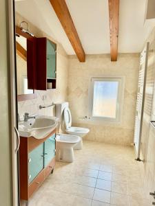a bathroom with a sink and a toilet and a window at Open space centre in Lignano Sabbiadoro