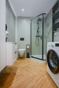 a bathroom with a shower and a washing machine at Dom Na Brzegu Ciszy in Pasym