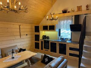 a living room with a table and a kitchen at Apartament Tatry&Pieniny in Szlachtowa