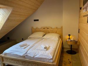 a bedroom with a bed with two towels on it at Apartament Tatry&Pieniny in Szlachtowa